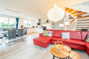 a living room with a red couch and a table at Kramerhof Ferienhaus Luv und Lee in Parow