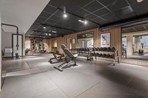 a gym with several treadmills and exercise machines at Home Hotel Astoria in Hamar