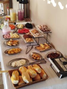 a table with many different types of bread and pastries at Pouso do parente in Pirenópolis