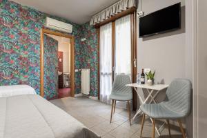 a bedroom with a bed and a table and chairs at Residenza Il Fiore in Bergamo