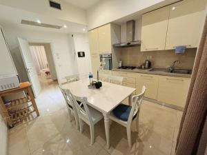 a kitchen with a white table and chairs in a room at Milano Central in Milan