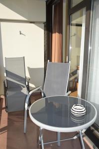 a glass table and two chairs in a room at Chalet Swiss - App.Nelles in Bad Füssing