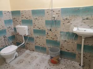 a bathroom with a toilet and a sink at Pindari Homestay in Bāgeshwar