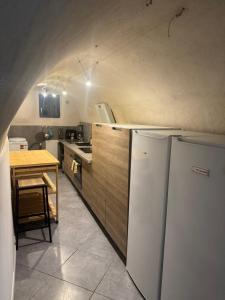 a kitchen with a white refrigerator and a table at Blue house in Saint-Gilles