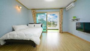 a bedroom with a white bed and a large window at Hwacheon Turkey Valley in Hwach'ŏn