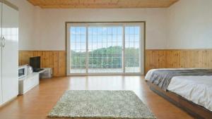 a bedroom with a bed and a large window at Hwacheon Turkey Valley in Hwach'ŏn