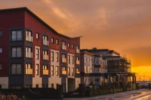 a group of buildings with the sunset in the background at Panoramic Sea-View Family Appartment , Free Parking, Sleeps 6 , Walk to Beach, Station, & Town in Newquay