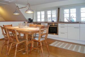 a kitchen with a wooden table and some chairs at Midlum- Peppin, OG in Midlum