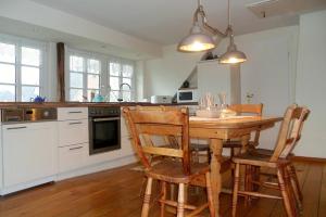 a kitchen with a wooden table and two chairs at Midlum- Peppin, OG in Midlum