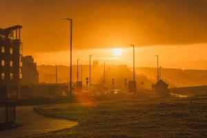a sunset over a city with cars on a street at Panoramic Sea-View Family Appartment , Free Parking, Sleeps 6 , Walk to Beach, Station, & Town in Newquay +36 photos