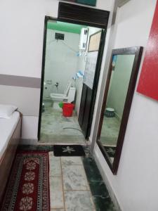 a bathroom with a toilet and a mirror at OP krishna homestay in Mathura