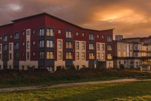 a large red building with a group of buildings at Panoramic Sea-View Family Appartment , Free Parking, Sleeps 6 , Walk to Beach, Station, & Town in Newquay