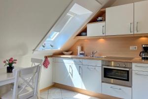 a kitchen with white cabinets and a sink and a window at MS Störtebecker, Sandwall in Wyk auf Föhr