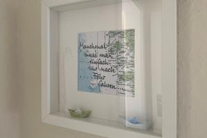 a white shelf with a picture on a wall at MS Störtebecker, Sandwall in Wyk auf Föhr