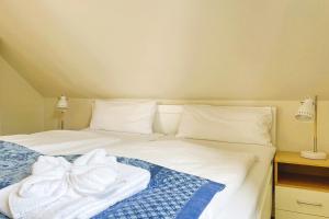 a bedroom with a bed with white sheets and pillows at MS Störtebecker, Sandwall in Wyk auf Föhr +7 photos
