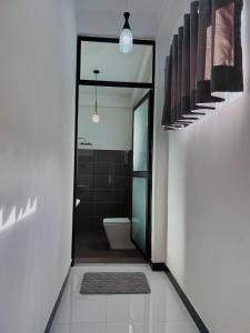 a bathroom with a toilet and a glass doorway at Climax View Point Inn in Bandarawela