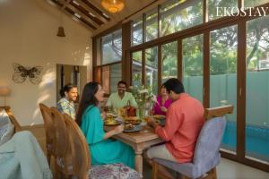 a group of people sitting around a table eating food at EKOSTAY - Assa Villa in Marna