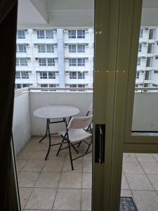 a table and chairs on a balcony with a window at Celadon Tower- Studio with balcony near SM San Lazaro in Manila