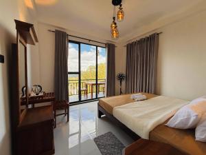 a bedroom with a bed and a view of a balcony at Climax View Point Inn in Bandarawela +63 photos