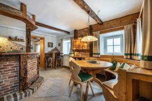 a living room with a table and a brick fireplace at Göglgut in Lungötz