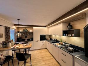 a kitchen with white cabinets and a table with chairs at Göglgut in Lungötz +9 photos