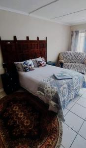 a bedroom with a large bed and a rug at Karoo House Guesthouse in Somerset East