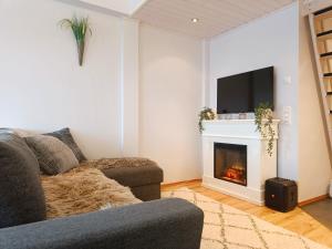 a living room with a couch and a fireplace at TunturinTähti in Syöte