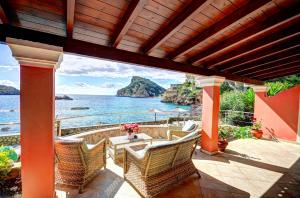 an outdoor patio with a view of the ocean at Yiannis Seafront Villa Paleokastritsa in Paleokastritsa