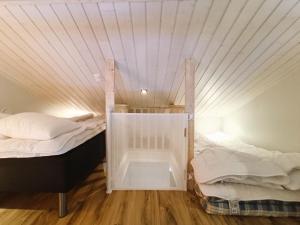 two twin beds in a room with a ceiling at TunturinTähti in Syöte