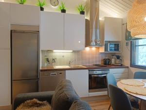 a kitchen with white cabinets and a table at TunturinTähti in Syöte