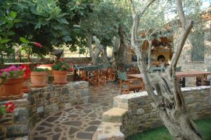 une terrasse avec une table, des chaises et des arbres dans l'établissement Villa Daphnis & Chloe, à Pyrgi Thermis
