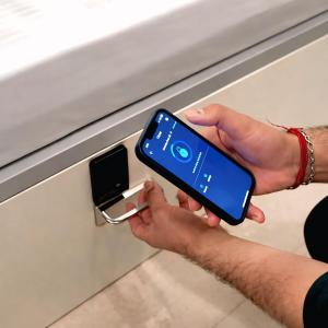 a person is holding a cell phone in a drawer at Metro POD Hotel at New Delhi Metro & Railway Station in New Delhi