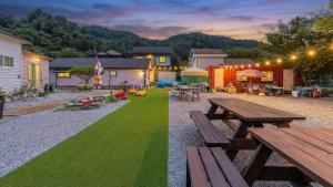 two views of a backyard with a picnic table and grass at Gapyeong Maplein Pension in Pocheon