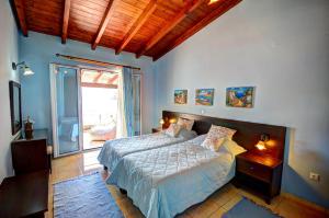 a bedroom with a bed and a large window at Yiannis Seafront Villa Paleokastritsa in Paleokastritsa