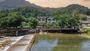 a bridge over a body of water with houses at Gapyeong Maplein Pension in Pocheon