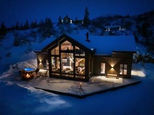 a cabin in the snow at night at FJELLRO Private Alpine Lodge Høgevarde in Flå