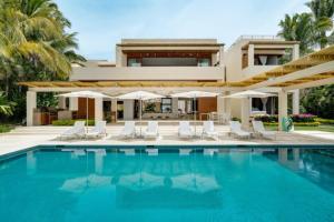 a villa with a swimming pool in front of a house at Villa Buho in Punta Mita in Punta Mita