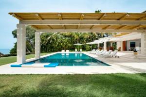 a swimming pool under a wooden pergola at Villa Buho in Punta Mita in Punta Mita