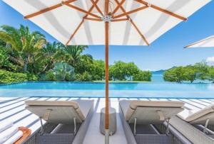 a patio with chairs and an umbrella and a swimming pool at Villa Brisa in Punta Mita in Punta Mita