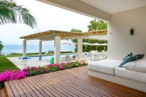 a bedroom with a bed and a deck with flowers at Villa Buho in Punta Mita in Punta Mita