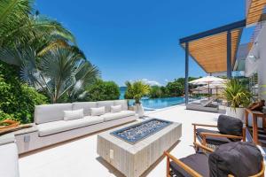 a patio with a white couch and a pool at Villa Brisa in Punta Mita in Punta Mita