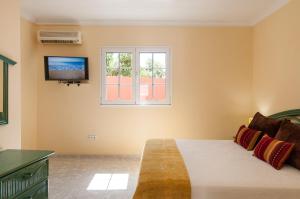 a bedroom with a bed and a tv on the wall at Sol y Mar El Salobre in Maspalomas