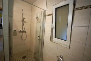 a bathroom with a shower with a mirror and a window at Beilsteiner Ferienwohnungen in Beilstein +27 photos