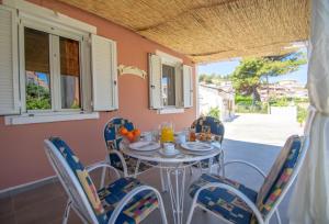 a table and chairs on the porch of a house at Dora's Beach Cottages in Planos