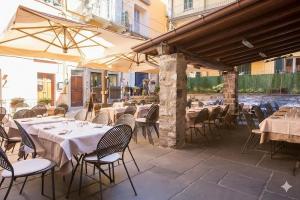 an outdoor restaurant with tables and chairs and umbrellas at Antico Pozzo Apartment in Bellagio
