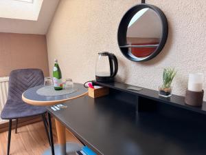 a mirror and a table with a bottle and a chair at daroomz in Gloggnitz