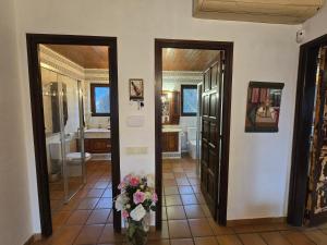 ein Badezimmer mit zwei Türen und einer Blumenvase in der Unterkunft Can Rossa in Palol de Oñar + 21 Fotos