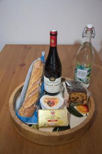 a basket of food with a bottle of wine and cheese at La Bonne Vie Gite in Chaunay