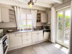 a kitchen with white cabinets and a large window at Ferienhaus Malve in Liepe