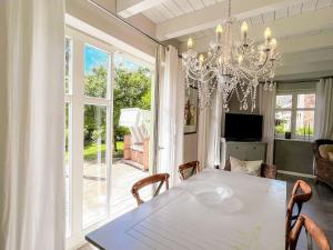 a dining room with a white table and a chandelier at Ferienhaus Malve in Liepe